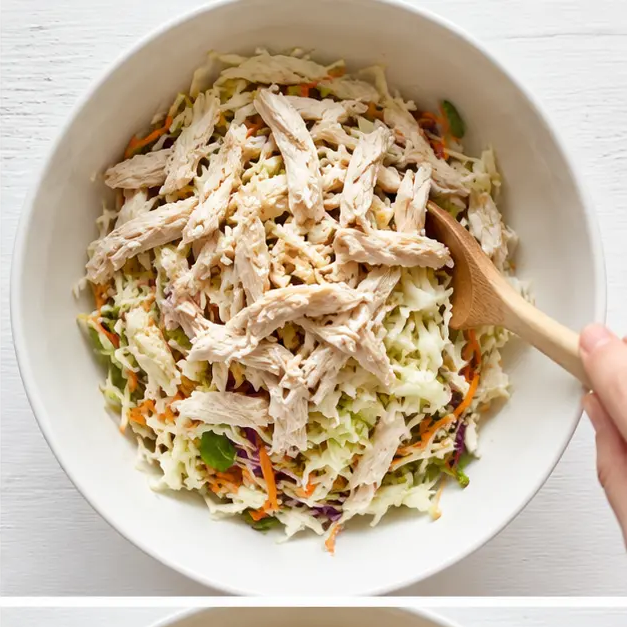 Step 2: Tossing shredded chicken with coleslaw mix