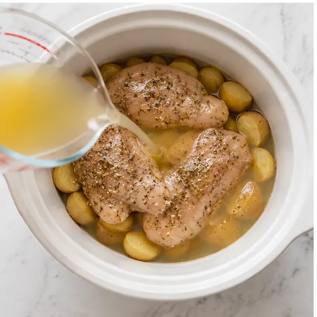 Step 3: Pouring chicken broth over the chicken and potatoes