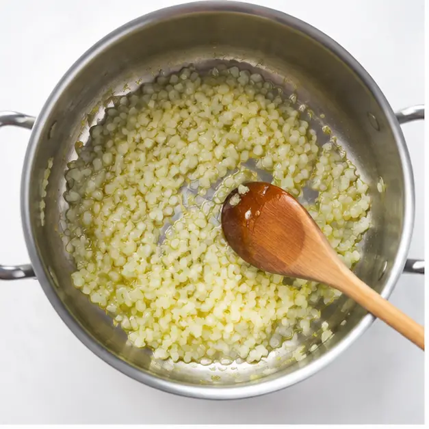 Step 1: Sautéing finely diced onion in olive oil until translucent