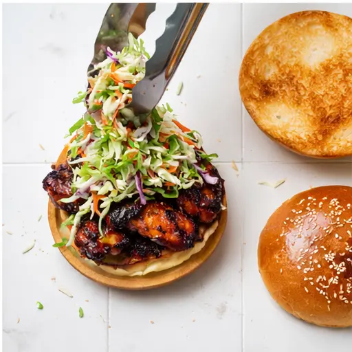 Step 4: Layering the grilled chicken and slaw on a toasted brioche bun