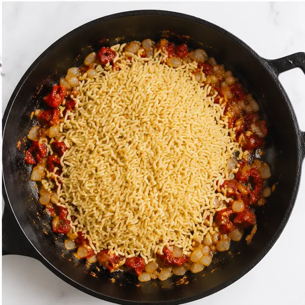 Step 4: Adding dry orzo to the pan