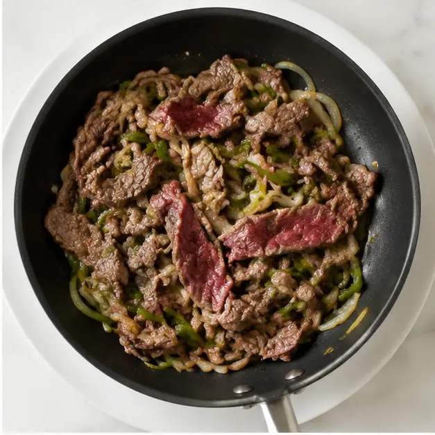 Step 2: Adding thinly sliced sirloin steak to the pan