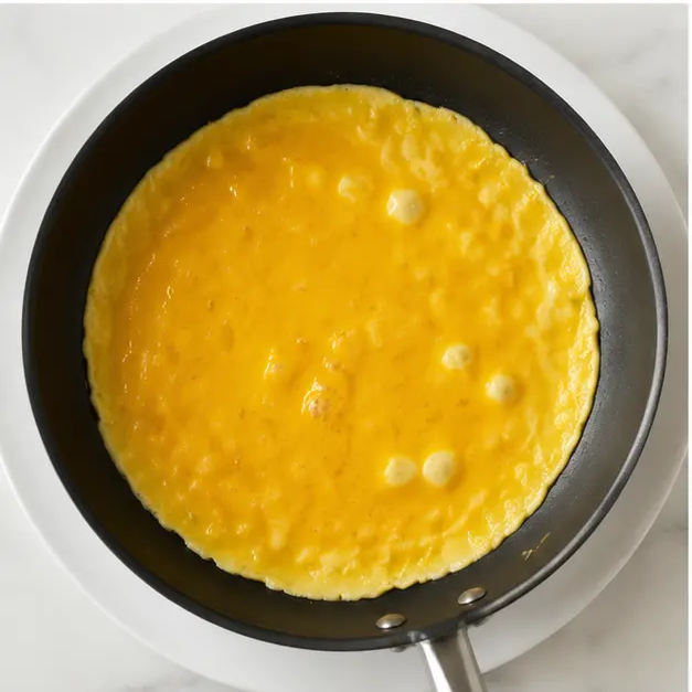 Step 3: Pouring beaten eggs into the hot skillet