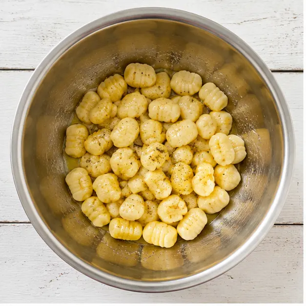 Step 1: Tossing raw gnocchi in oil and seasonings