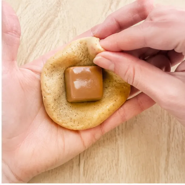 Step 2: Wrapping dough around a soft caramel candy and sealing it