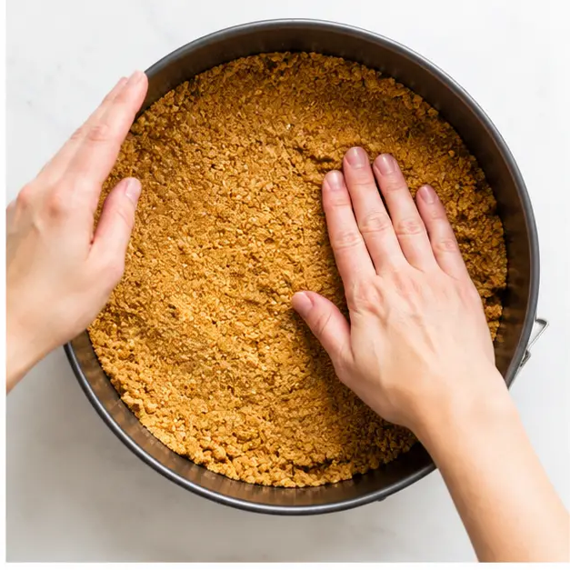 Press the buttery graham cracker crust into the pan
