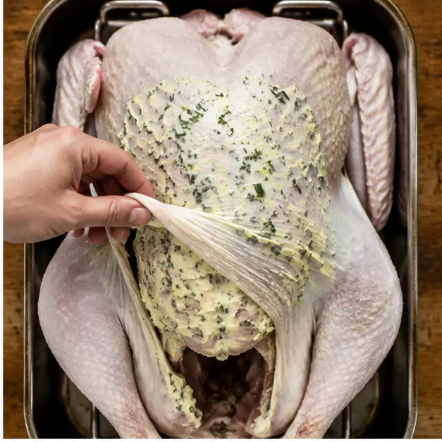 Step 2: Spreading garlic herb butter under the turkey skin