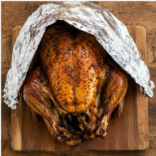Step 4: Resting the roasted turkey under foil before carving