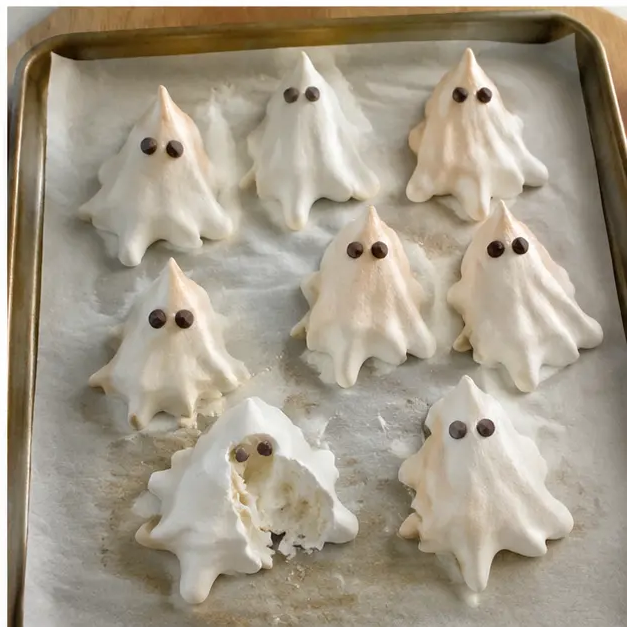 Pressing chocolate chips into ghosts for eyes and baking