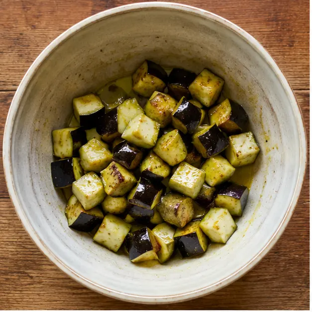 Step 1: Toss cubed eggplant with olive oil in a large mixing bowl