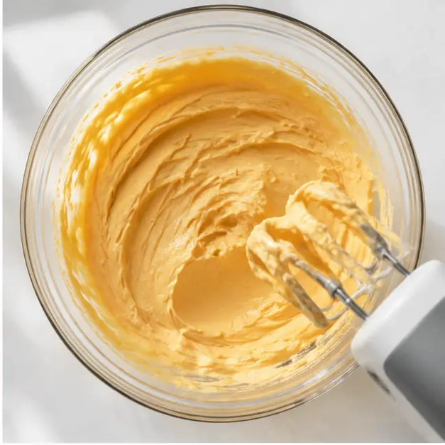 Beating softened cream cheese with pumpkin puree into the silky filling
