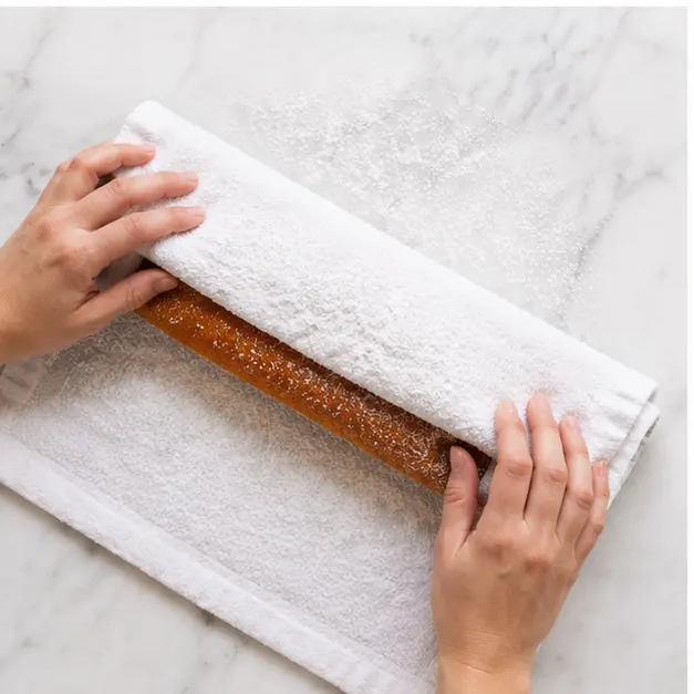 Step 3: Rolling the warm cake in a sugared kitchen towel