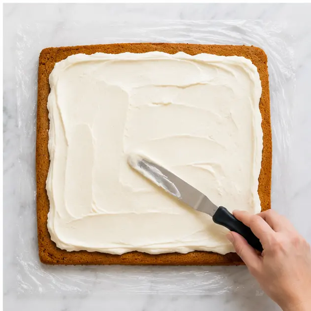 Step 4: Spreading the silky cream cheese filling onto the cake