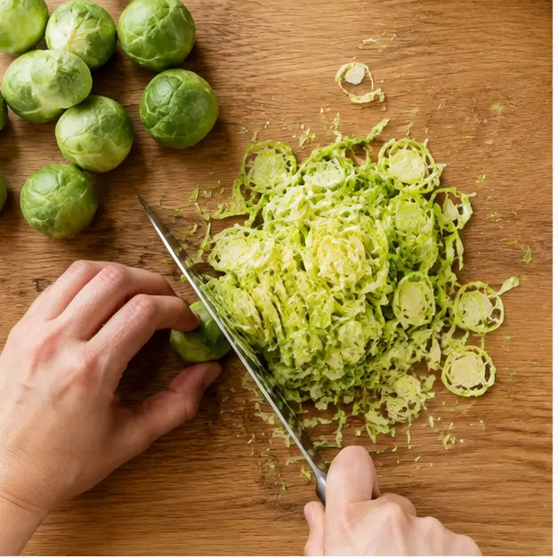 Step 1: Shaving raw Brussels sprouts into thin pale green ribbons