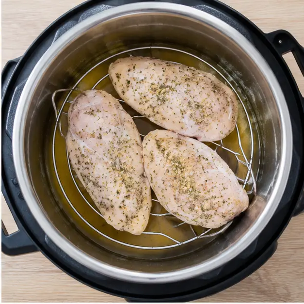 Step 2: Arranging seasoned frozen chicken fillets on trivet over broth in the pressure cooker