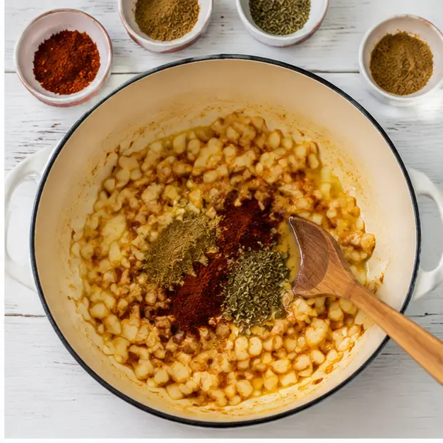 Step 2: Blooming ground cumin and chili powder with garlic in hot oil